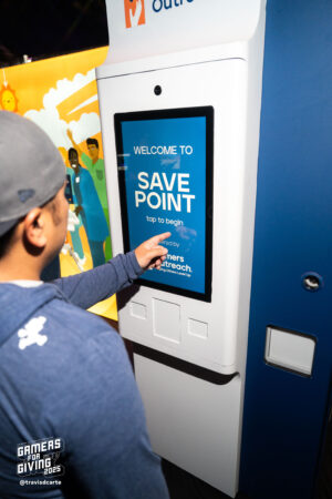 Someone using a Gamers Outreach Save Point machine.